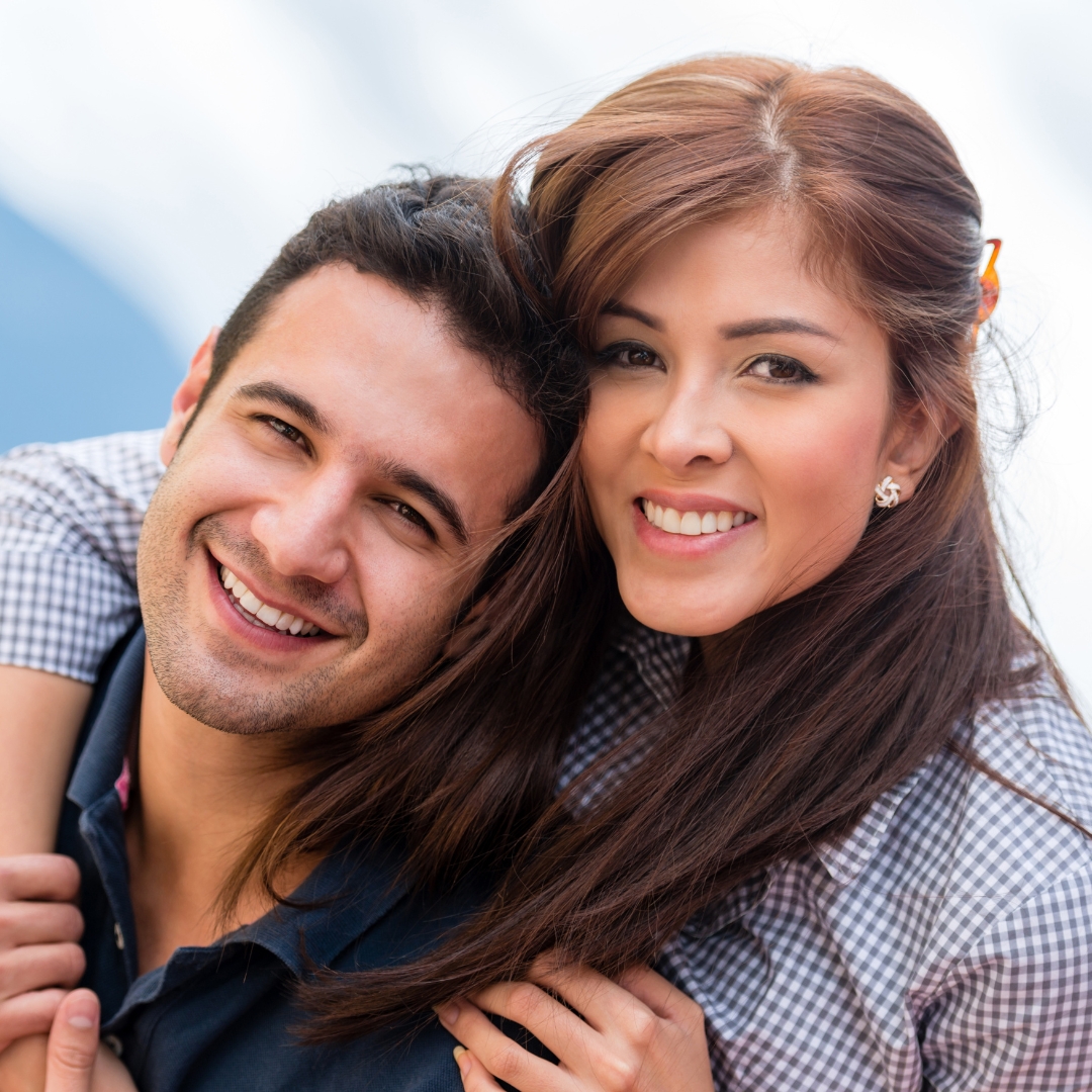 Smiling couple with healthy teeth after dental implants
