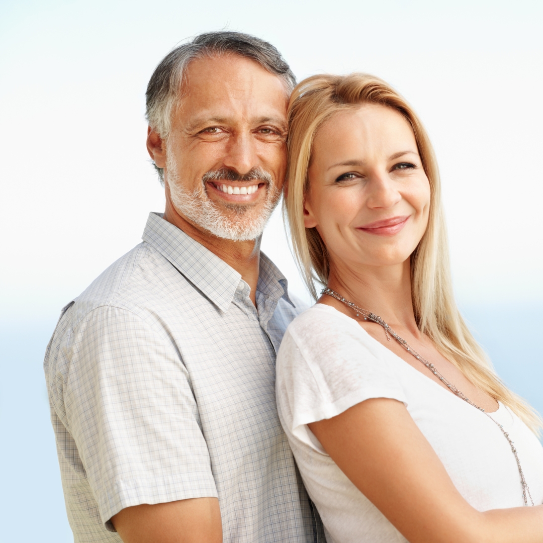 Smiling mature couple after dental implant treatment