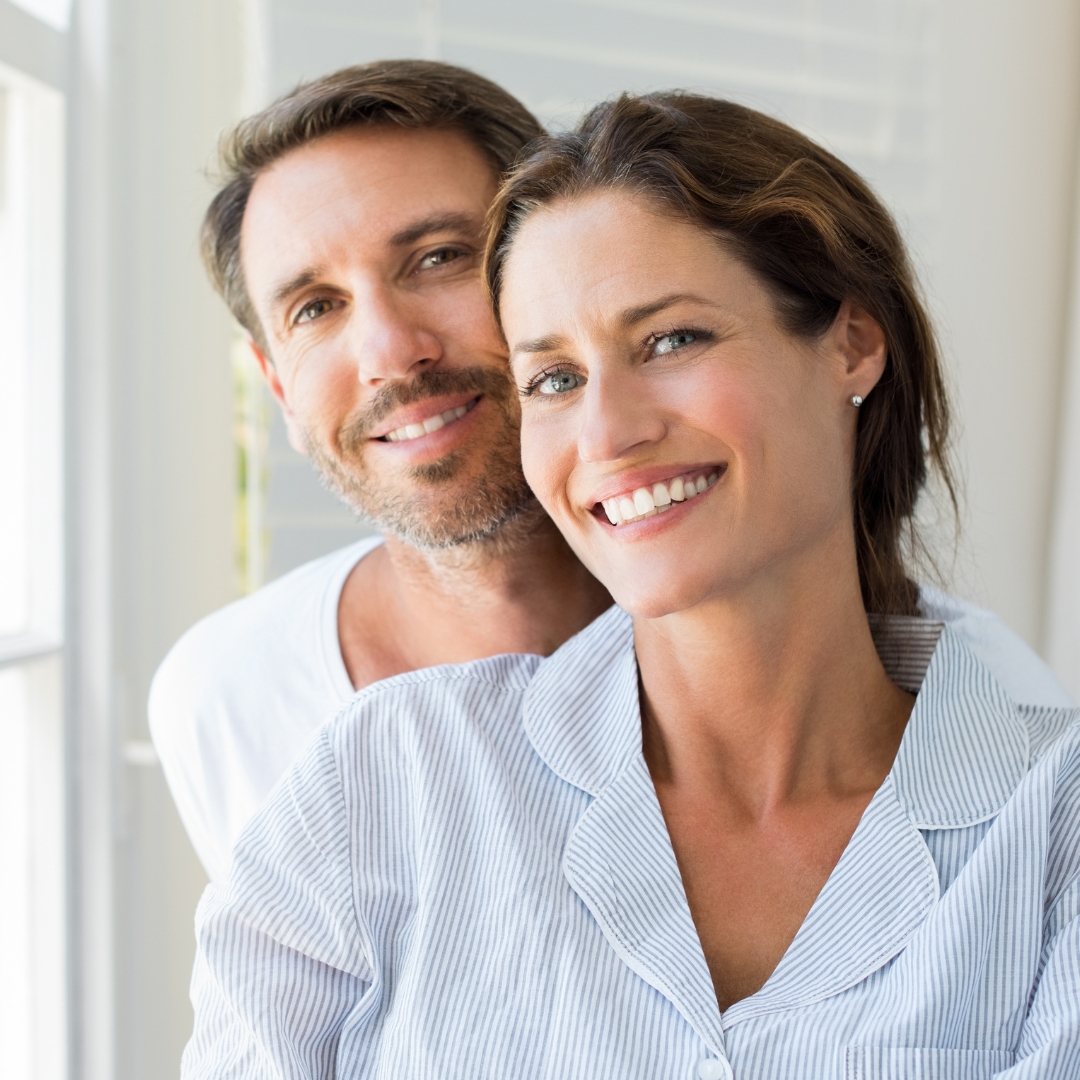Happy couple smiling after dental implant treatment