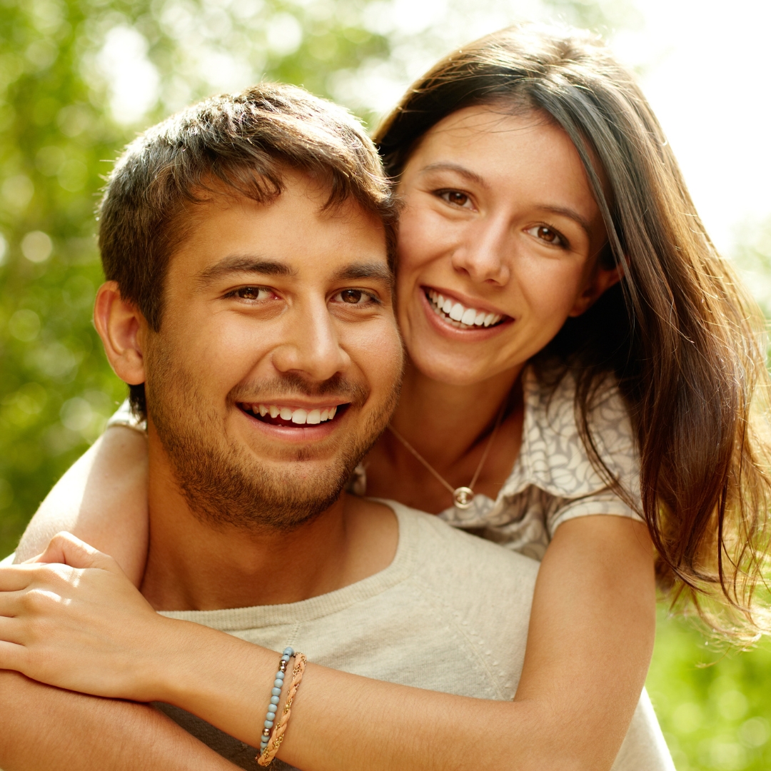 Happy young couple smiling outdoors